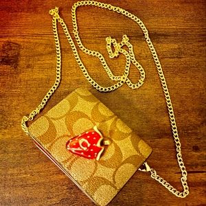 Coach NWOT strawberry charm mini clutch in signature brown & red leather.